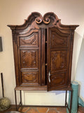 Antique two-door carved walnut cabinet on iron stand