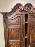 Antique two-door carved walnut cabinet on iron stand