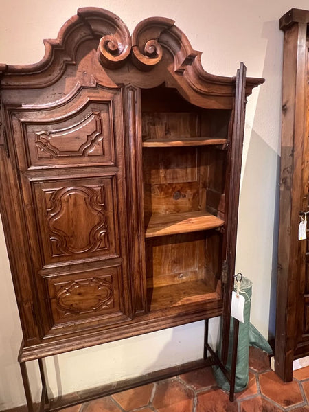 Antique two-door carved walnut cabinet on iron stand