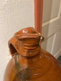 Antique glazed rust colored single-handle jug