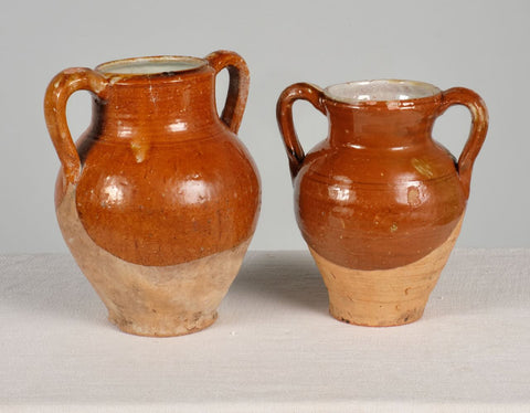 Antique pair of two-handle glazed oil jugs
