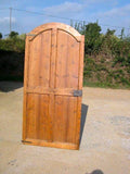 Single-panel honey pine arched door