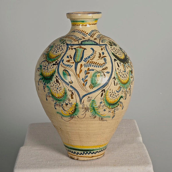 Large antique painted and glazed single handle water jug, “Blue and green flower with pomegranate on shield”