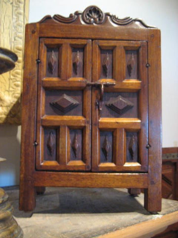 Reproduction mini armoire with carved walnut panels and crest