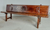 Antique trestle leg walnut bench with carved sun symbols