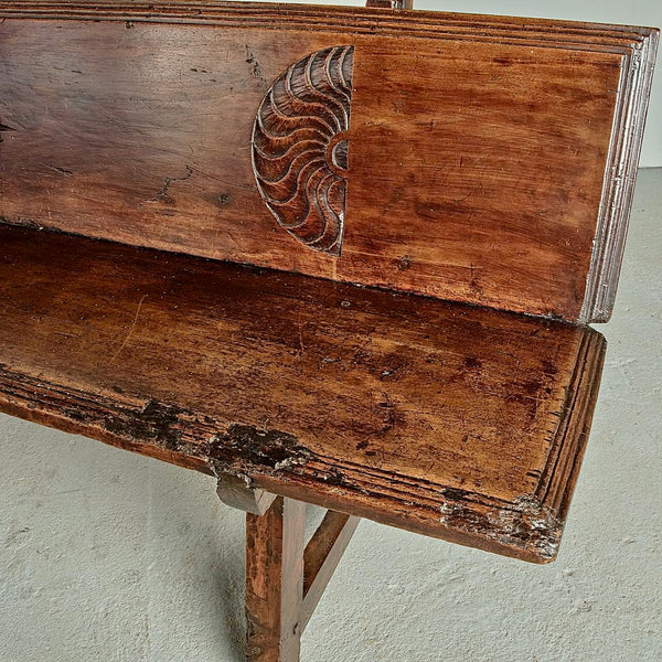 Antique trestle leg walnut bench with carved sun symbols